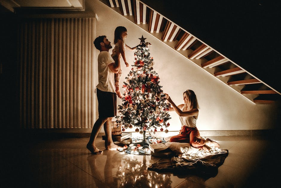 Illustration of a family gathered around a Christmas tree, decorating it with ornaments and lights, with smiles on their faces and a warm atmosphere.